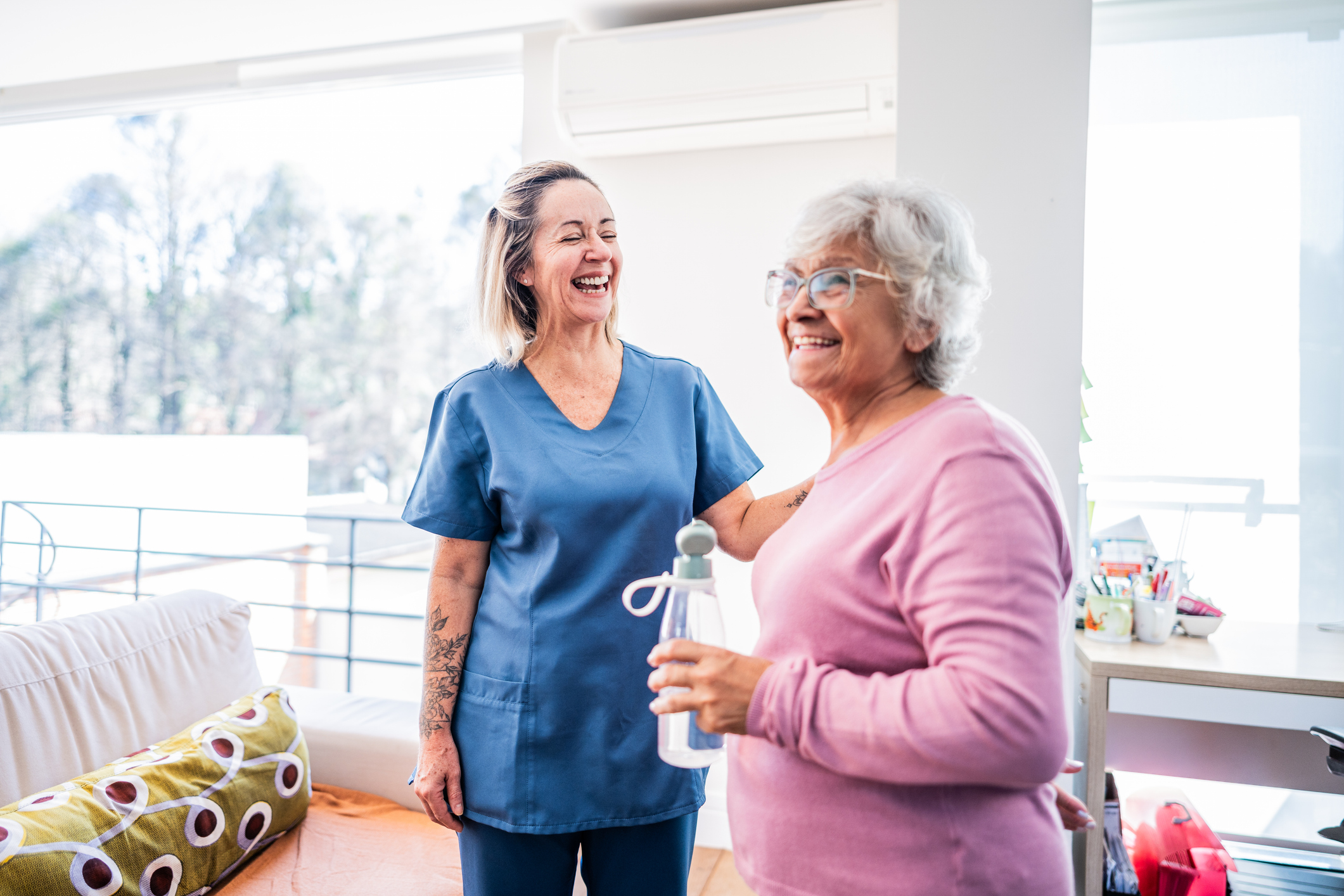 Senior woman with water bottle chatting with a medical professional
